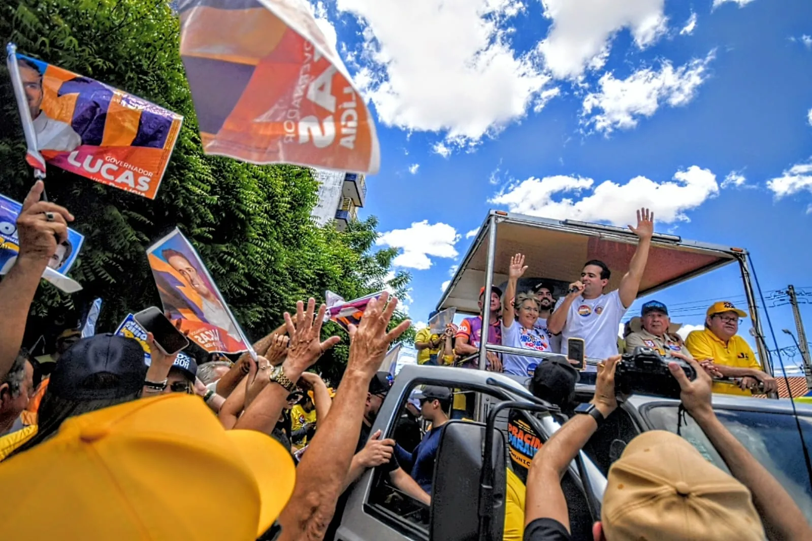 Lucas Ribeiro discursa ao microfone com o braço erguido ao lado de Leninha Romão, Zé Aldemir, João Azevêdo, Nabor Wanderley e Wilson Filho.