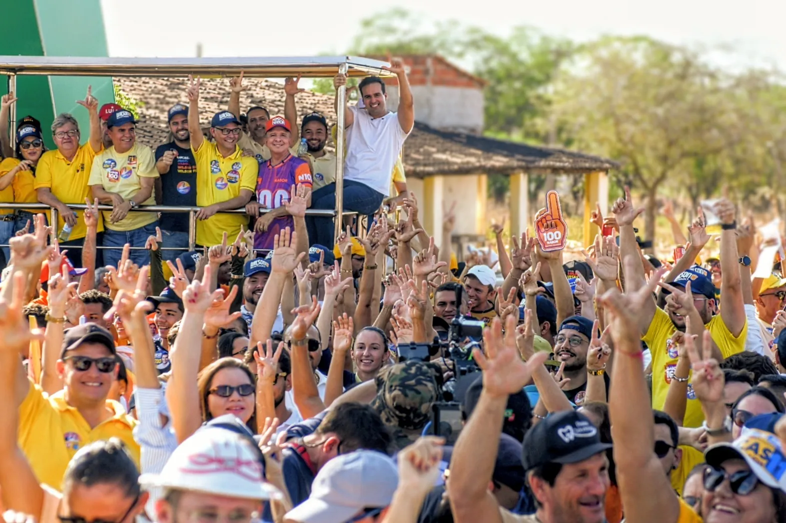 Lucas Ribeiro, João Azevêdo, Nabor Wanderley e lideranças acenam em cima de carro cercados por multidão com braços erguidos.